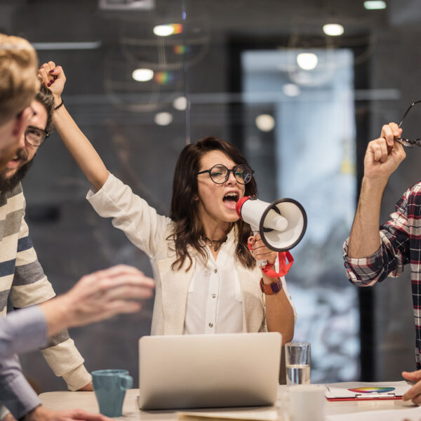 Bossy female leader encouraging her coworkers to work harder in the office.